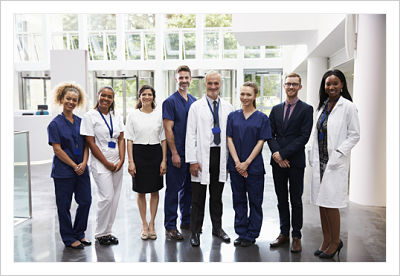 Group of Physicians and Nurses, smiling. There is five females and three males.